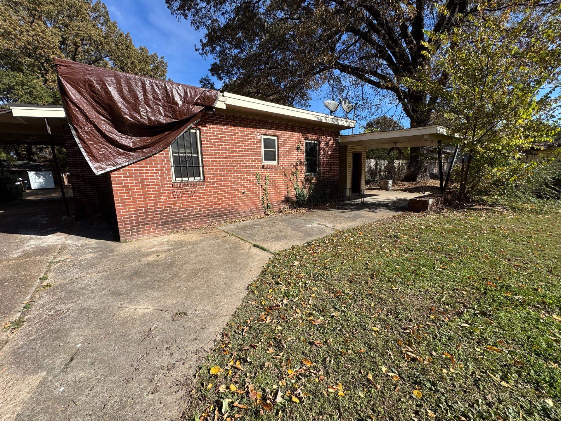 3085 Hoskins Road Memphis, TN 38111 - Photo 14 of 14 View of side of property with brick siding, a yard, an attached carport, and driveway