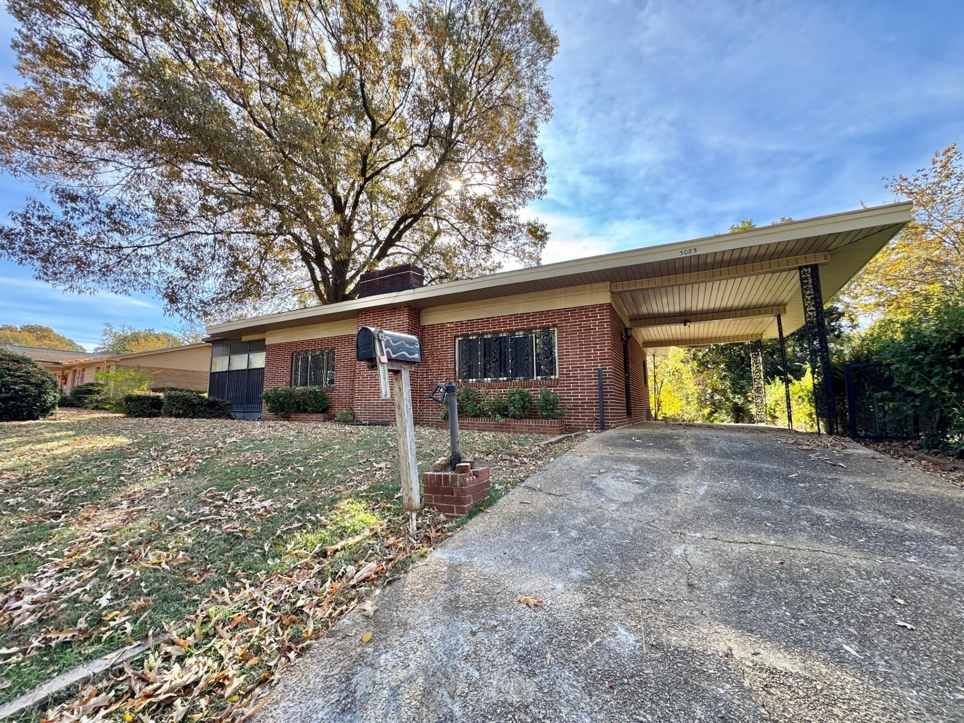 3085 Hoskins Road Memphis, TN 38111 - Photo 2 of 14 Ranch-style home with an attached carport, concrete driveway, brick siding, and a front yard