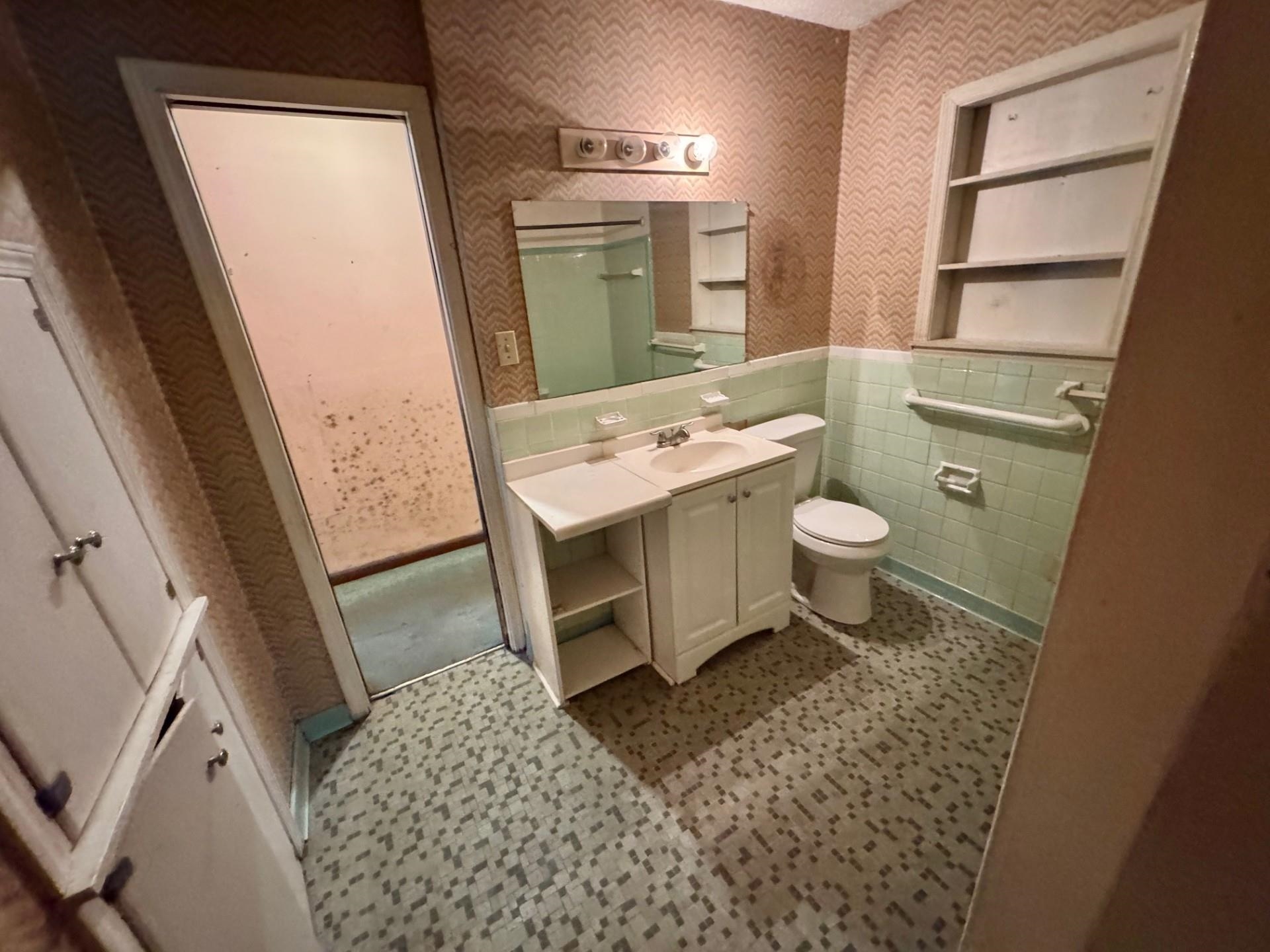3085 Hoskins Road Memphis, TN 38111 - Photo 10 of 14 Bathroom with wallpapered walls, vanity, wainscoting, and tile walls