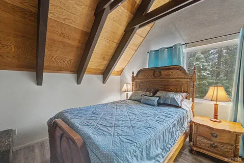 a bedroom with a bed a mirror and next to a window