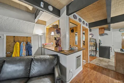 a living room with stainless steel appliances kitchen island granite countertop a refrigerator and a stove
