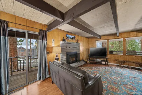 a living room with furniture a fireplace and a floor to ceiling window