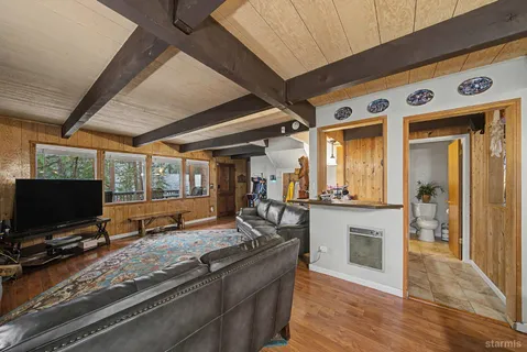 a living room with stainless steel appliances kitchen island granite countertop furniture and a flat screen tv