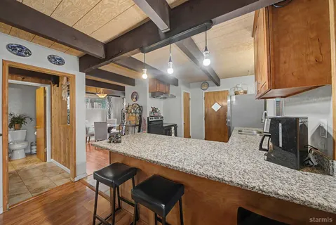 a view of a kitchen with granite countertop a sink and cabinets