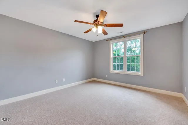 a view of a room with a ceiling fan and window