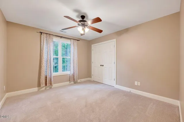 an empty room with a window and a ceiling fan