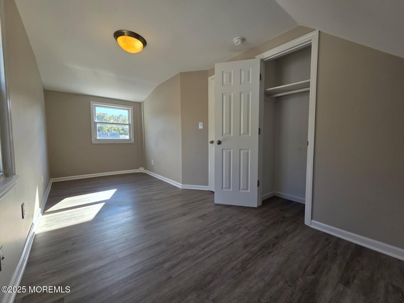 6 Trumen Place, Unit 1 Keansburg, NJ 07734 - Photo 14 of 19 an empty room with wooden floor and windows