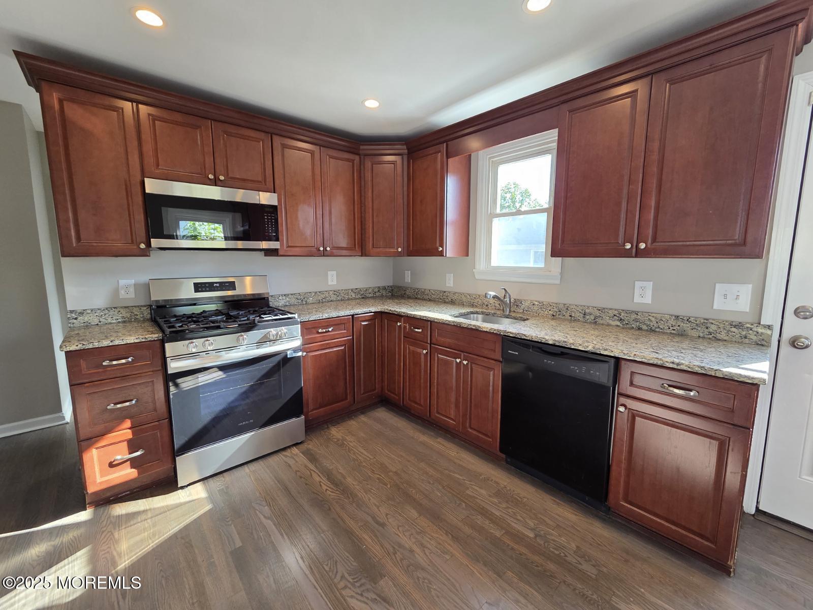 6 Trumen Place, Unit 1 Keansburg, NJ 07734 - Photo 4 of 19 a kitchen with granite countertop wooden cabinets stainless steel appliances and a window