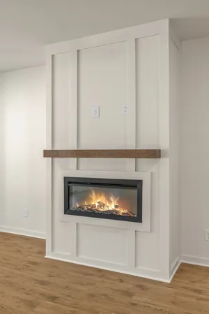 an empty room with wooden floor ceiling fan and windows