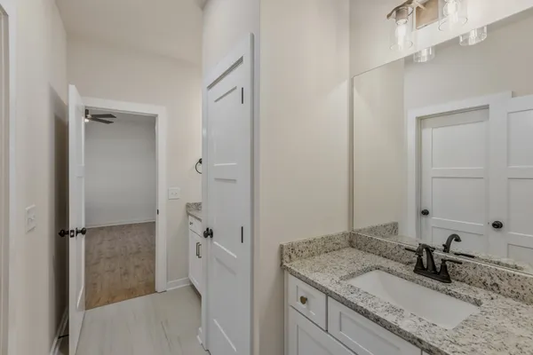 a bathroom with a granite countertop sink and a mirror