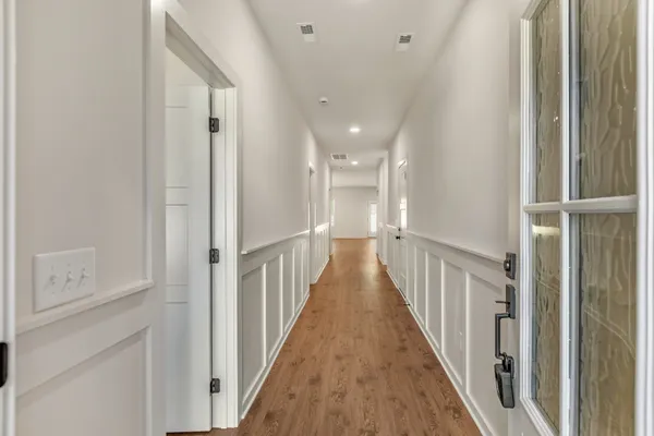 a view of a hallway with wooden floor and entryway