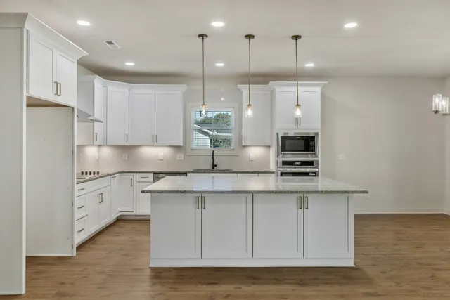 a kitchen with stainless steel appliances granite countertop a sink a stove and a refrigerator