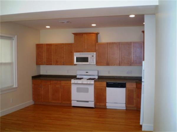 111 Heath Street Boston, MA 02120 - Photo 6 of 17 a kitchen with stainless steel appliances granite countertop wooden cabinets and a wooden floor