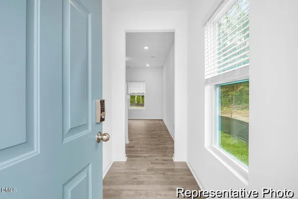 a view of hallway with wooden floor and a rug