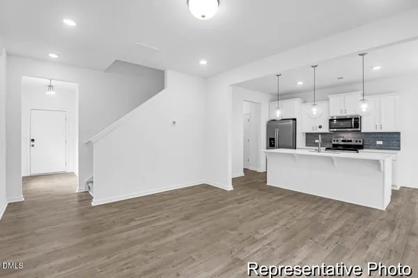 a view of kitchen with stainless steel appliances refrigerator oven microwave and cabinets