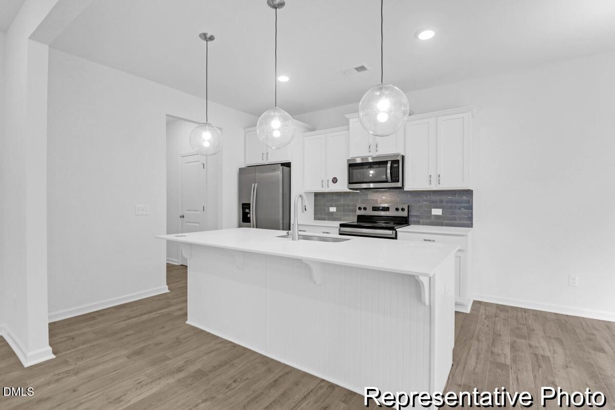 40 Birchstone Trail, Unit 225P Erwin, NC 28339 - Photo 8 of 26 a kitchen with stainless steel appliances granite countertop a sink a stove a refrigerator and island with wooden floor