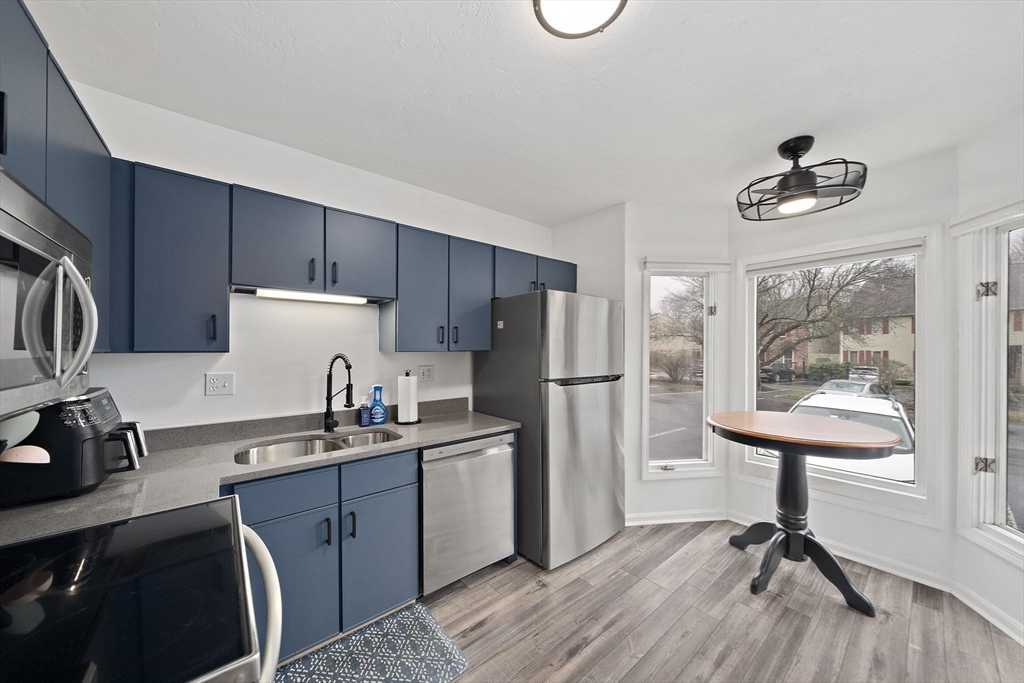 22 Union Square, Unit 22 Randolph, MA 02368 - Photo 8 of 28 a kitchen with a refrigerator a sink and cabinets