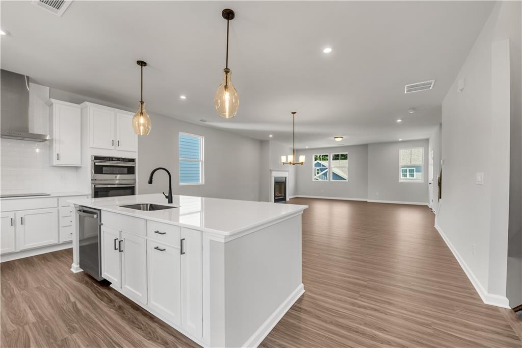 644 Devon Alley Acworth, GA 30102 - Photo 11 of 32 a kitchen with stainless steel appliances granite countertop a sink a stove and a wooden floors