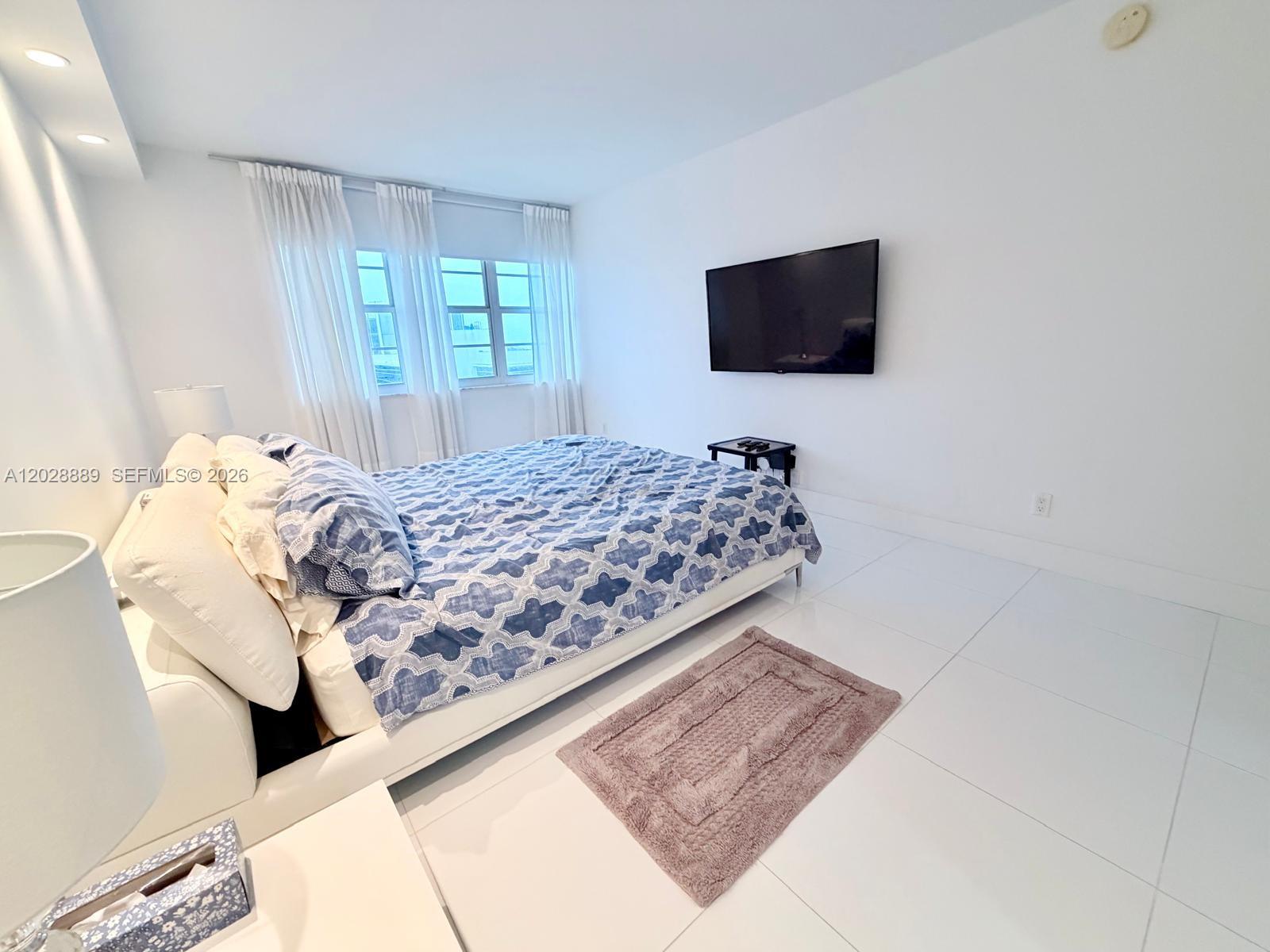 100 Lincoln Road, Unit 1504 Miami Beach, FL 33139 - Photo 11 of 17 a bedroom with a bed and flat screen tv