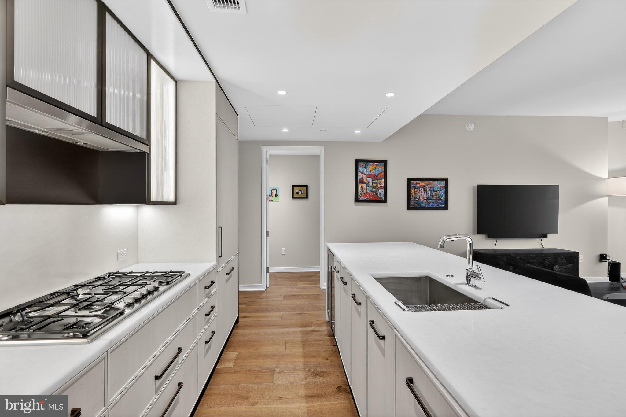 601 Wharf Street Southwest, Unit 1107 Washington, DC 20024 - Photo 11 of 26 a large white kitchen with sink and stainless steel appliances