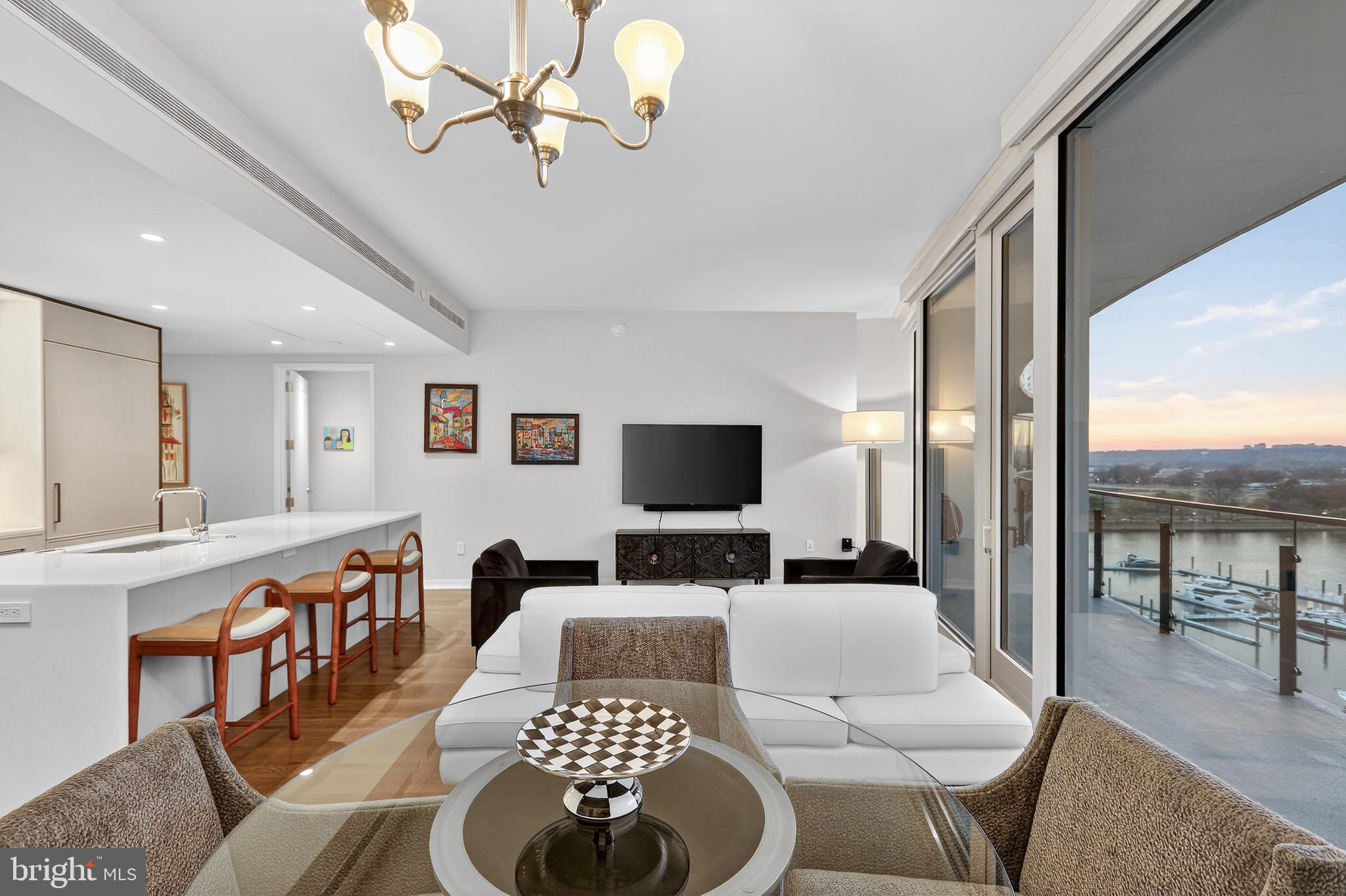 601 Wharf Street Southwest, Unit 1107 Washington, DC 20024 - Photo 16 of 26 a living room with furniture a rug and a chandelier