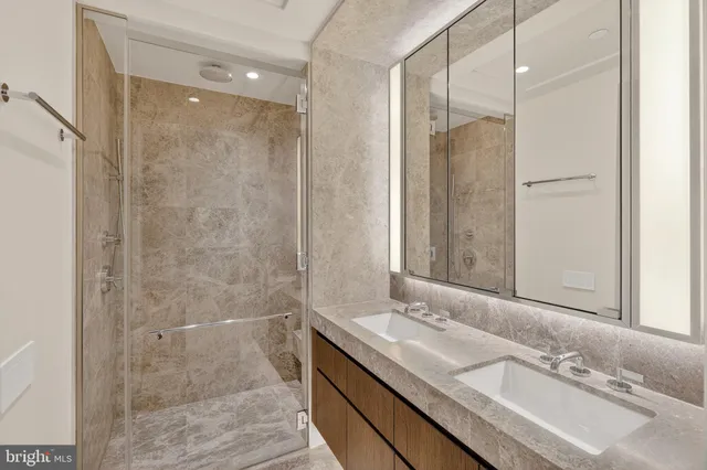 a bathroom with a granite countertop sink shower and a mirror