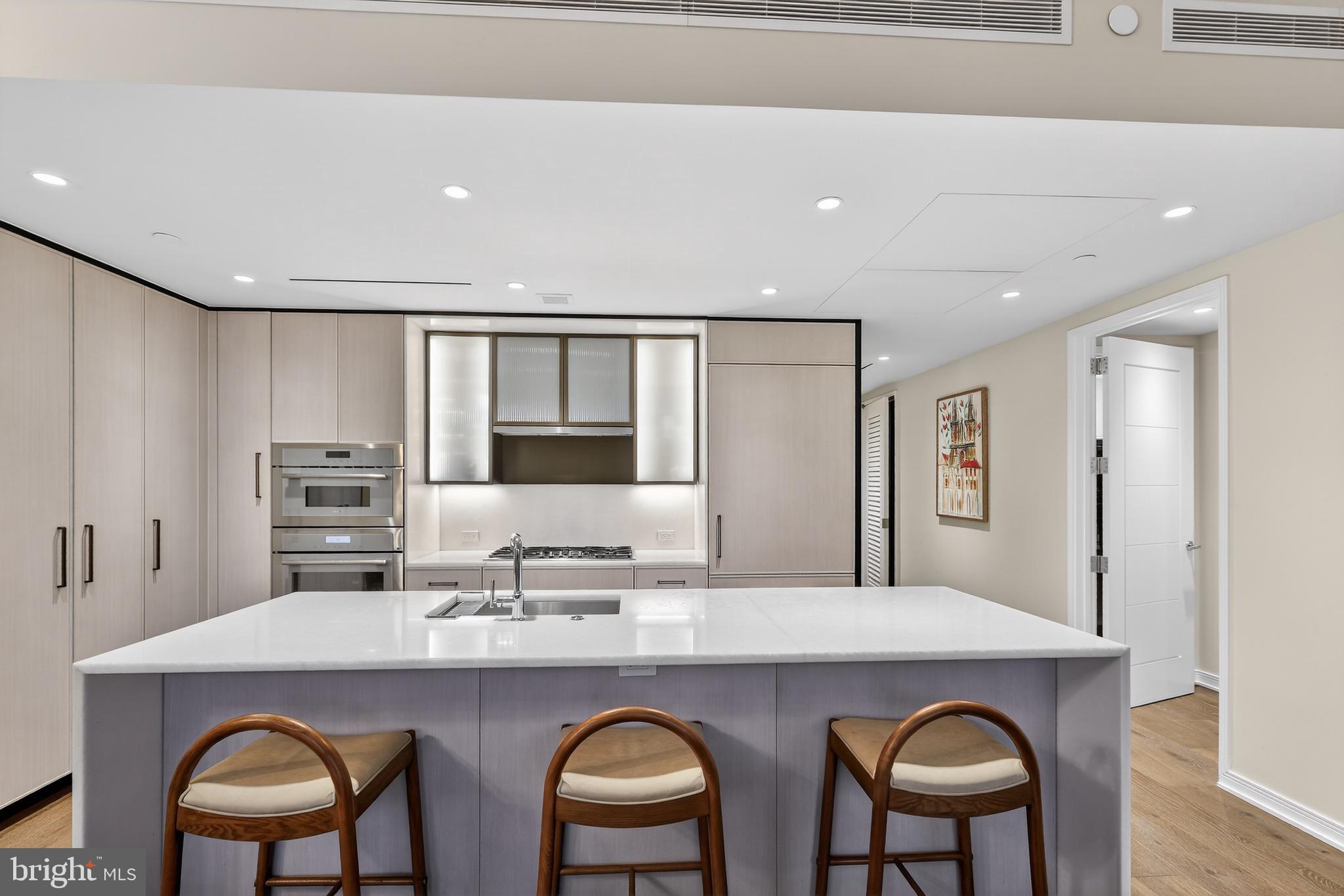 601 Wharf Street Southwest, Unit 1107 Washington, DC 20024 - Photo 9 of 26 a kitchen with stainless steel appliances granite countertop a table chairs sink and cabinets