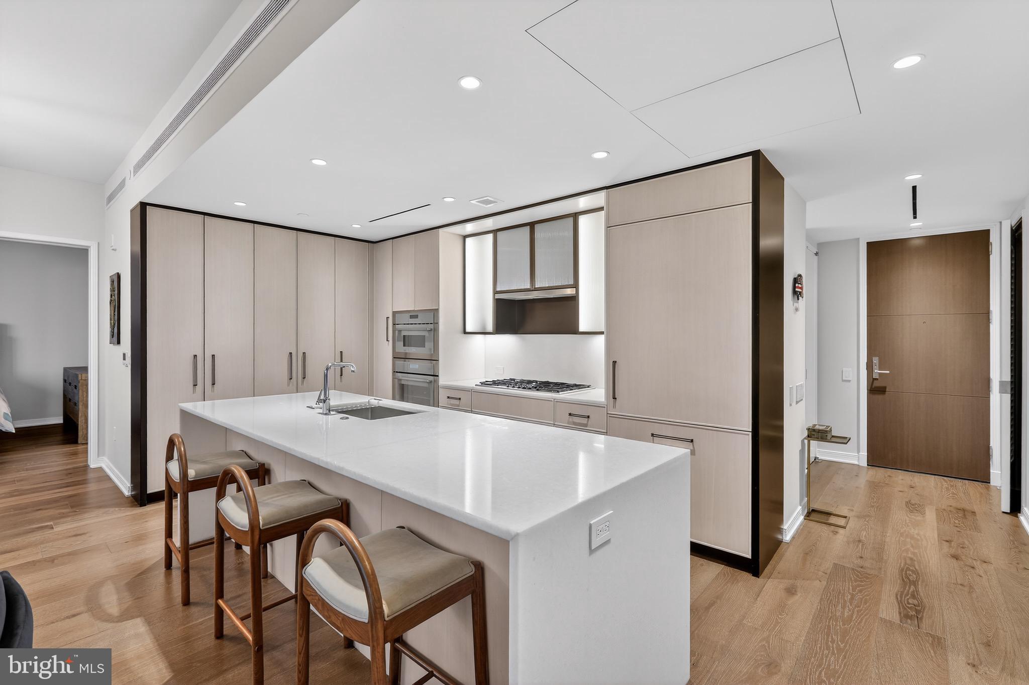 601 Wharf Street Southwest, Unit 1107 Washington, DC 20024 - Photo 10 of 26 a kitchen with stainless steel appliances granite countertop a table chairs refrigerator and sink