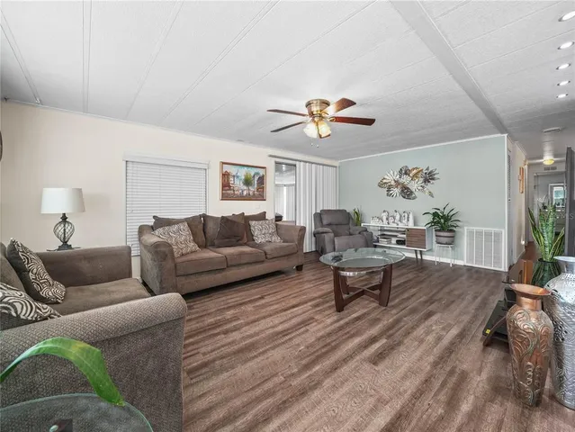 a living room with furniture kitchen view and a large window