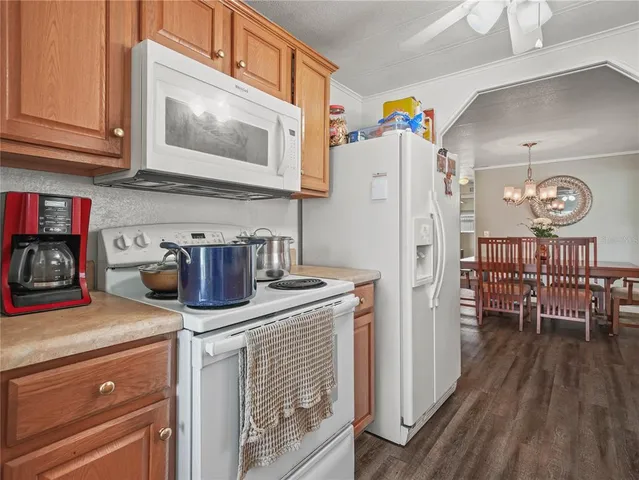 a kitchen with granite countertop a refrigerator stove top oven and sink
