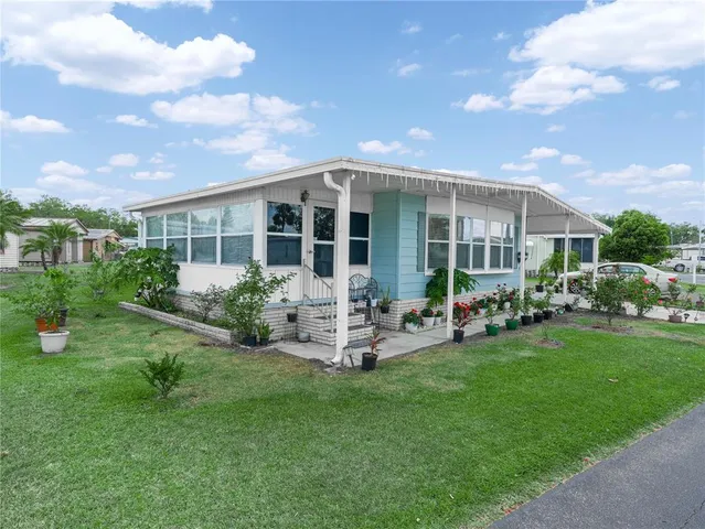 a view of a house with backyard sitting area and garden