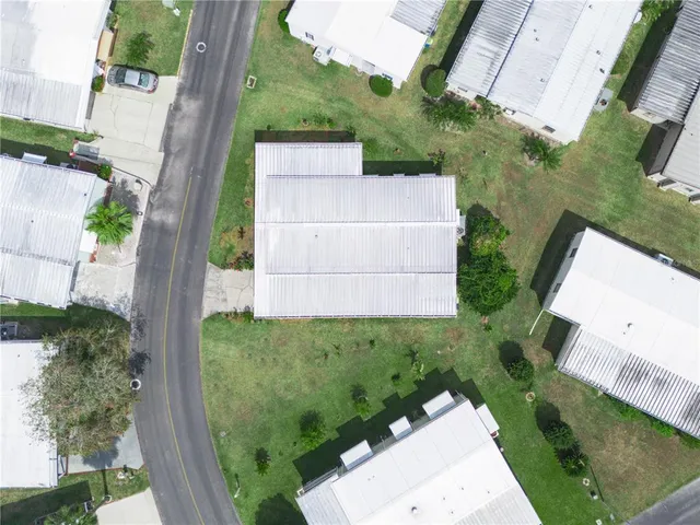 an aerial view of a house with a garden and lots of residential buildings