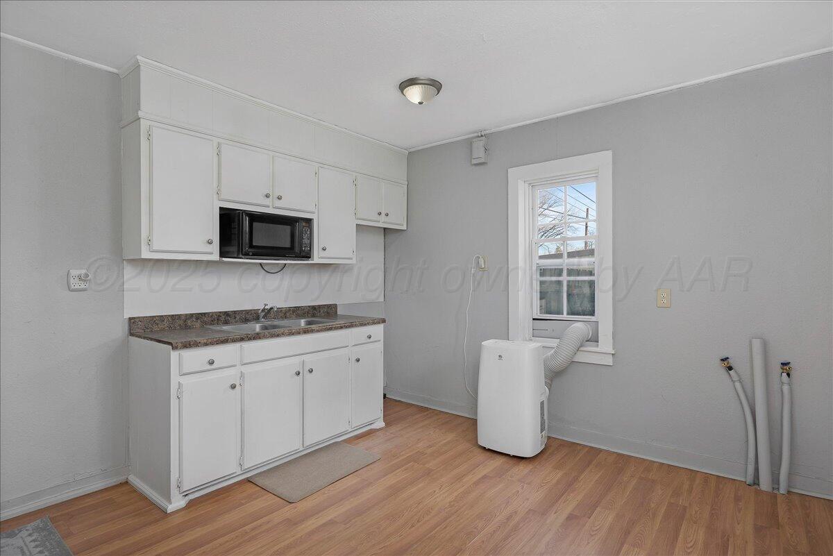2007 6th Avenue Canyon, TX 79015 - Photo 27 of 33 a kitchen with granite countertop a stove a sink and a microwave
