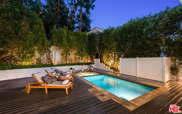 a room with a table chairs and potted plant
