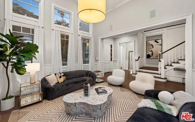 a living room with furniture a fireplace and a view of kitchen