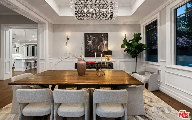 a living room with furniture kitchen view and a chandelier