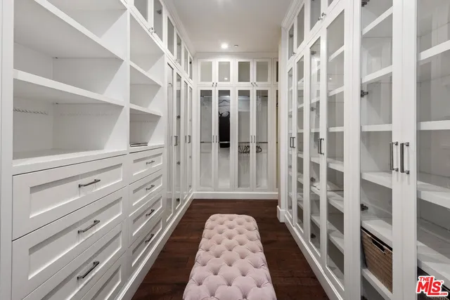 a view of a patio with dining table and chairs under an umbrella with large trees