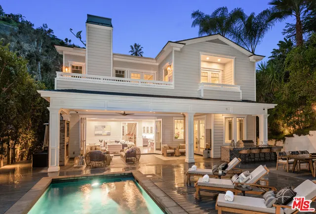 a living room with furniture fireplace and large windows