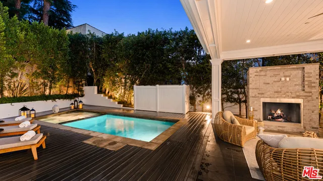 a living room with furniture a fireplace and a large mirror