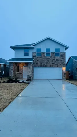 a front view of a house with yard and parking