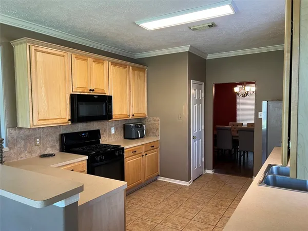 a kitchen with stainless steel appliances granite countertop a sink a stove and a refrigerator