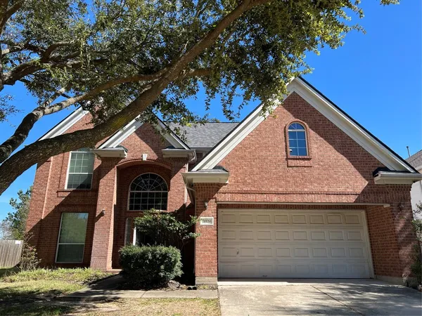 a front view of a house with a tree
