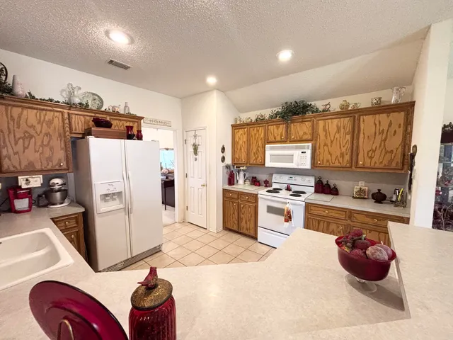 a kitchen with a refrigerator and white cabinets