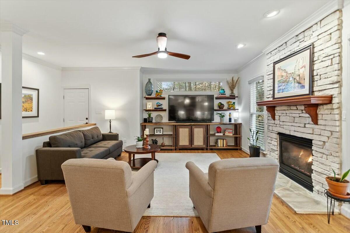 407 Crickentree Drive Cary, NC 27518 - Photo 18 of 78 a living room with furniture a fireplace and a large window