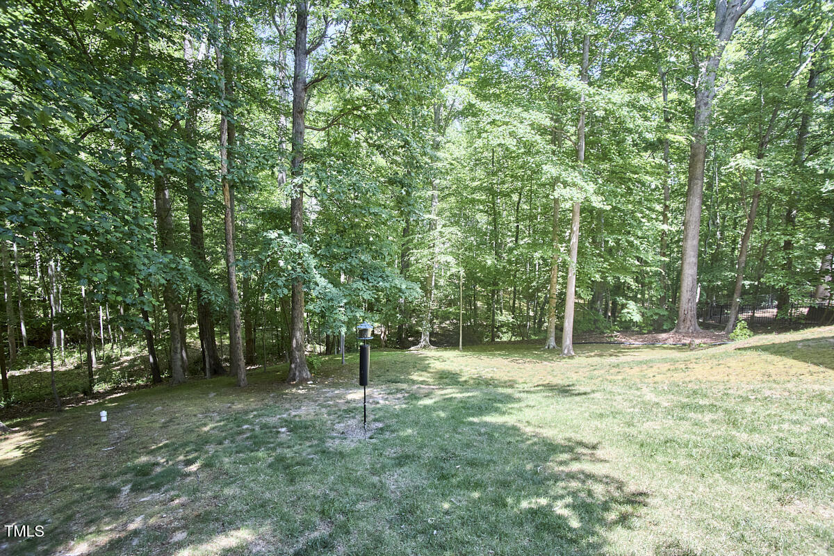 407 Crickentree Drive Cary, NC 27518 - Photo 71 of 78 a backyard of a house with lots of plants and large tree