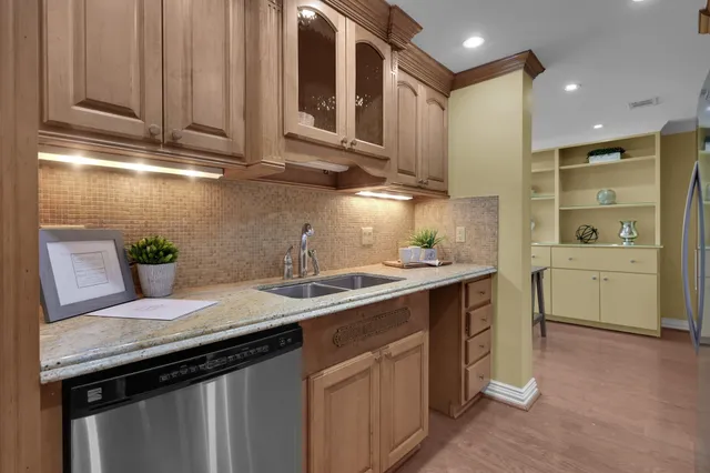 a kitchen with stainless steel appliances granite countertop a sink a stove and a cabinets