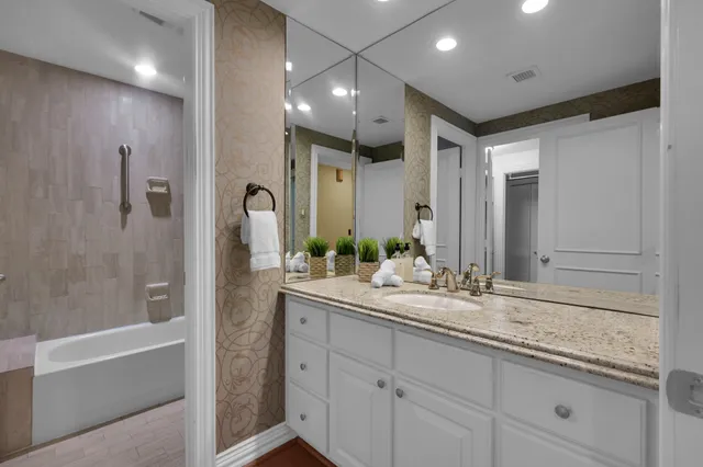 a bathroom with a sink double vanity granite tub and shower