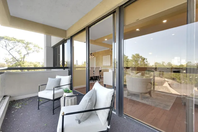 a living room with patio furniture and a floor to ceiling window