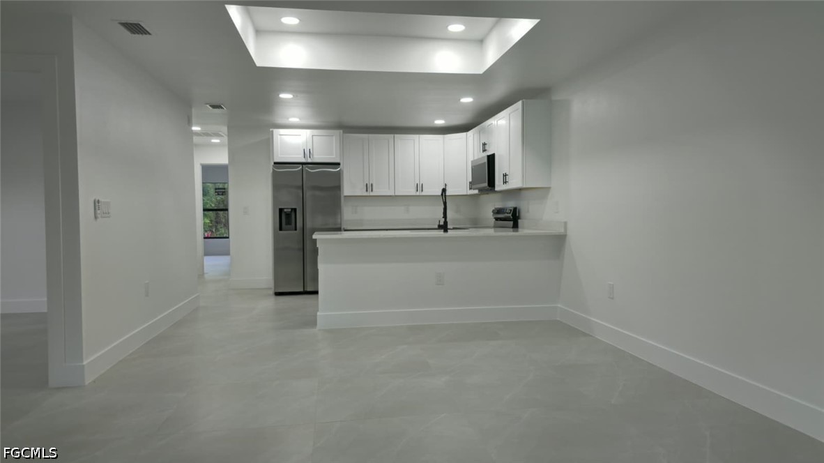 4429 26th Street Southwest Lehigh Acres, FL 33973 - Photo 11 of 16 a view of a kitchen with a sink and a refrigerator