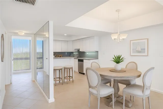 a kitchen with kitchen island a dining table chairs stainless steel appliances and cabinets